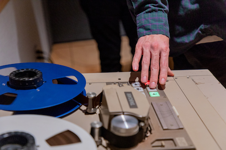 A student uses the 16-track tape machine during Analog Recording class.
