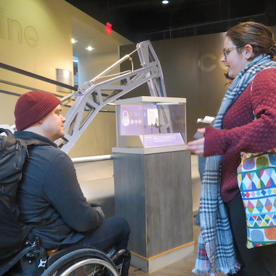 A student speaks with workshop leader Ben Baker about accessibility in the Franklin Institute.