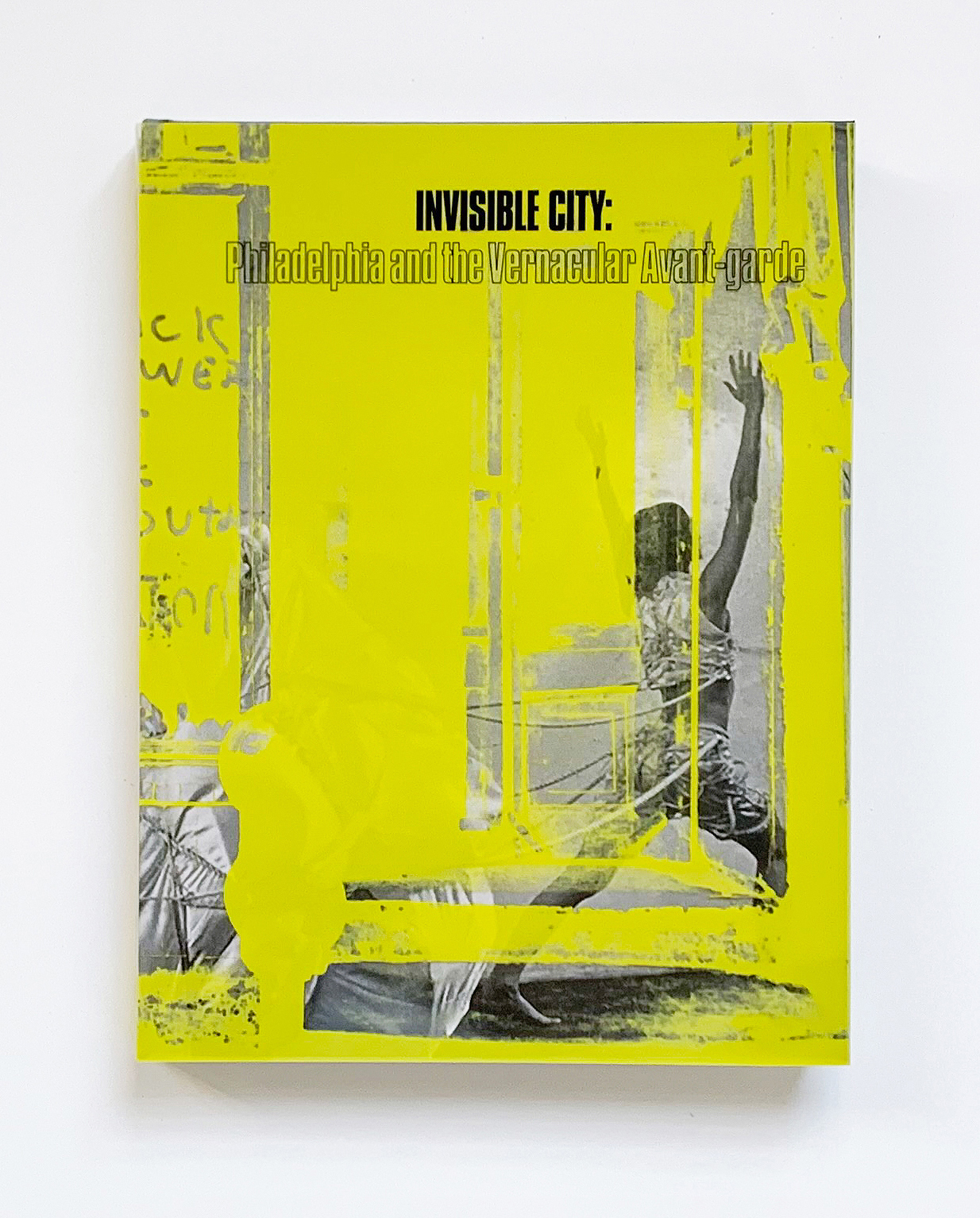 Invisible City catalog cover with neon yellow overlay