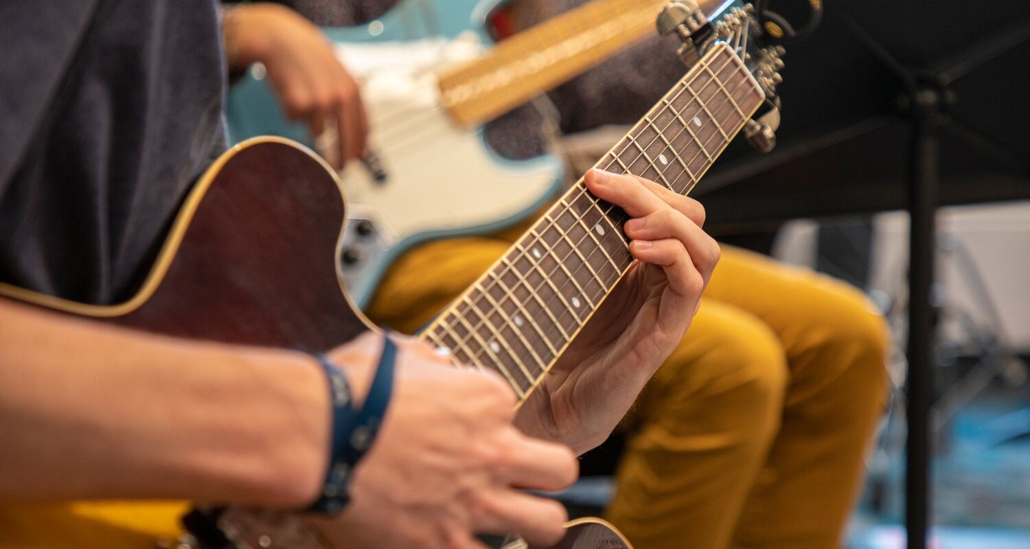 A closeup of hands playing a guitar