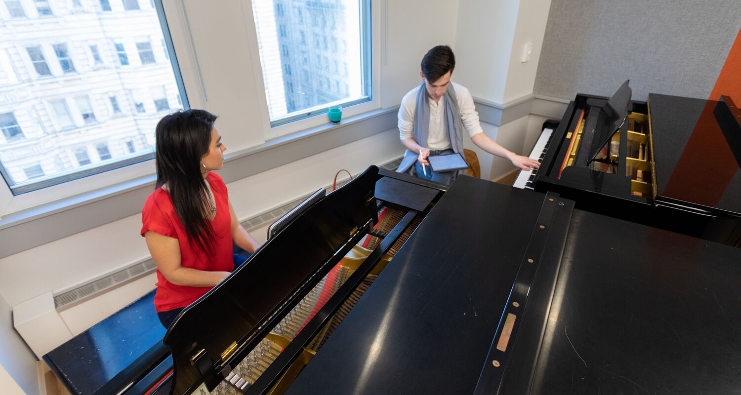UArts student plays at a piano with a professor AJ Luca