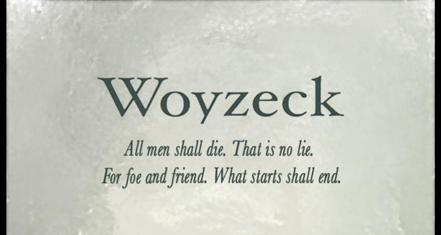 An image of a village. At the top it says in green writing “Woyzeck All men shall die. That is no lie. For foe and friend. What starts shall end.”