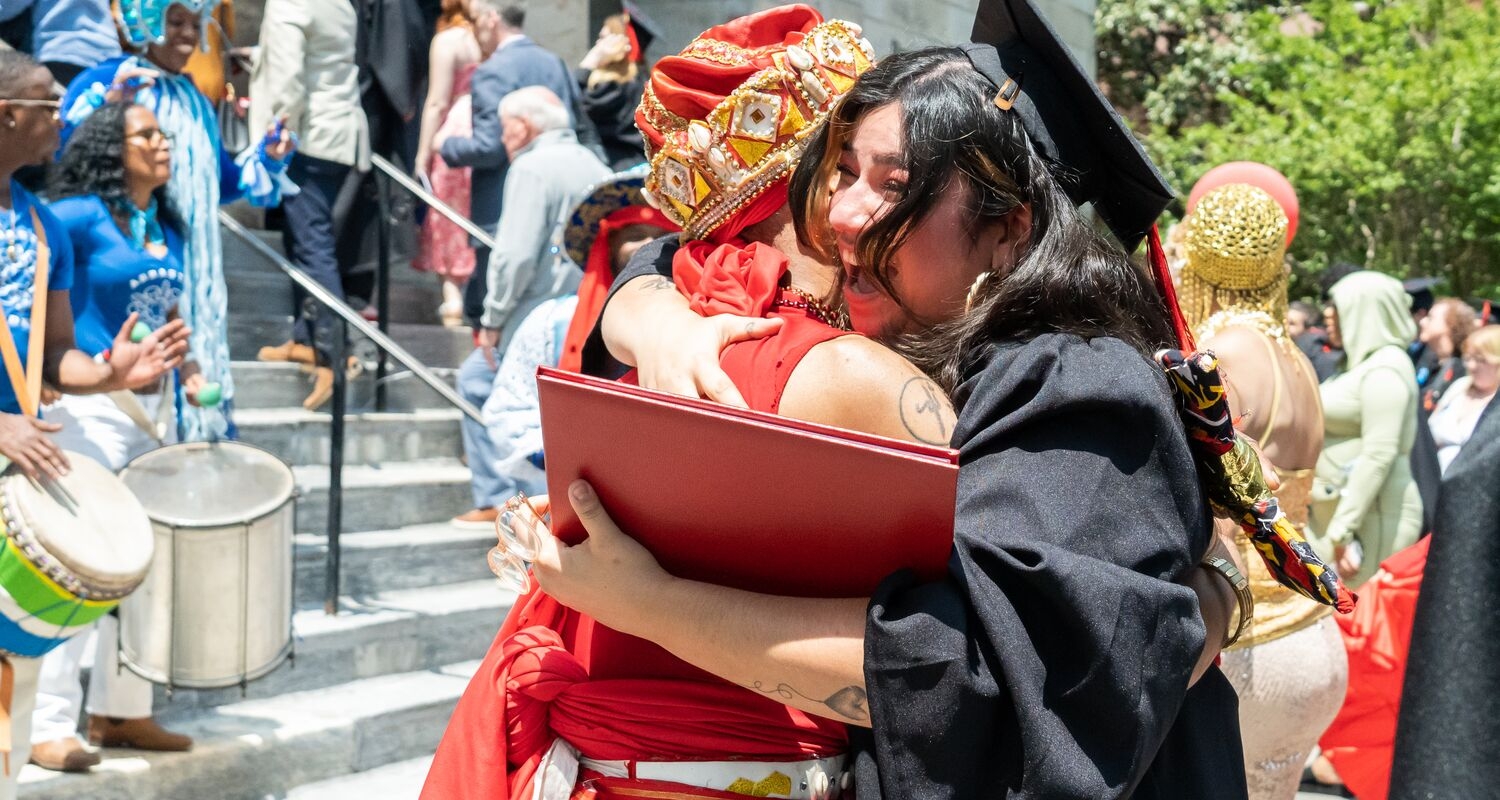 Student after graduation hugging parent in front of the steps of Hamilton 