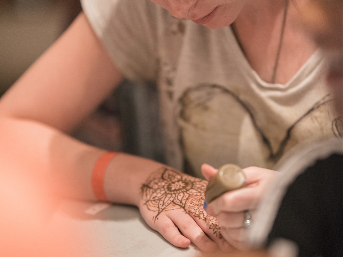 A student concentrates on creating henna art during Henna Night