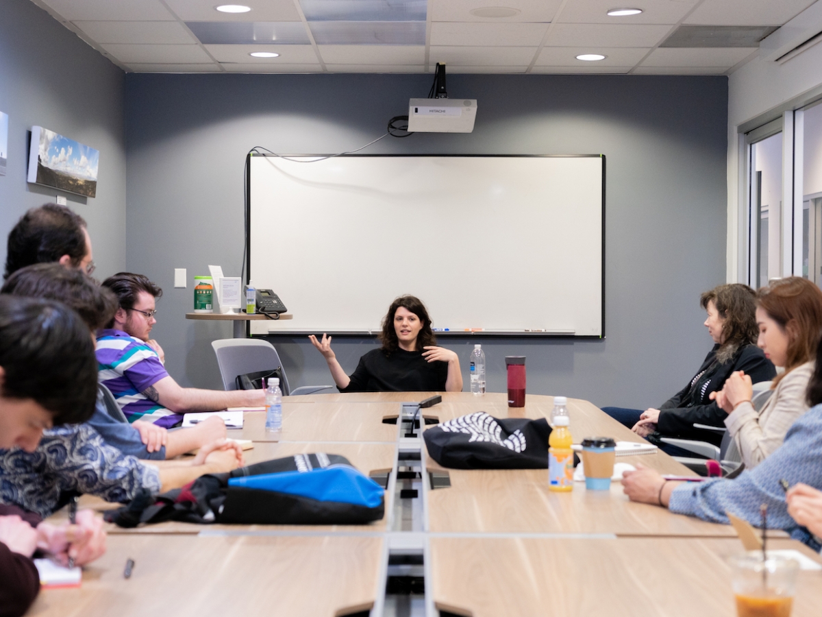 Students and faculty sit around a conference room table and learn from alum Jenn Wexler BFA '08 (WFTV). 