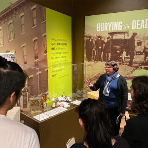Students look at the exhibit "Burying the Dead" with a tour guide at the Mutter Museum.