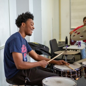 A drummer rehearses with their small ensemble