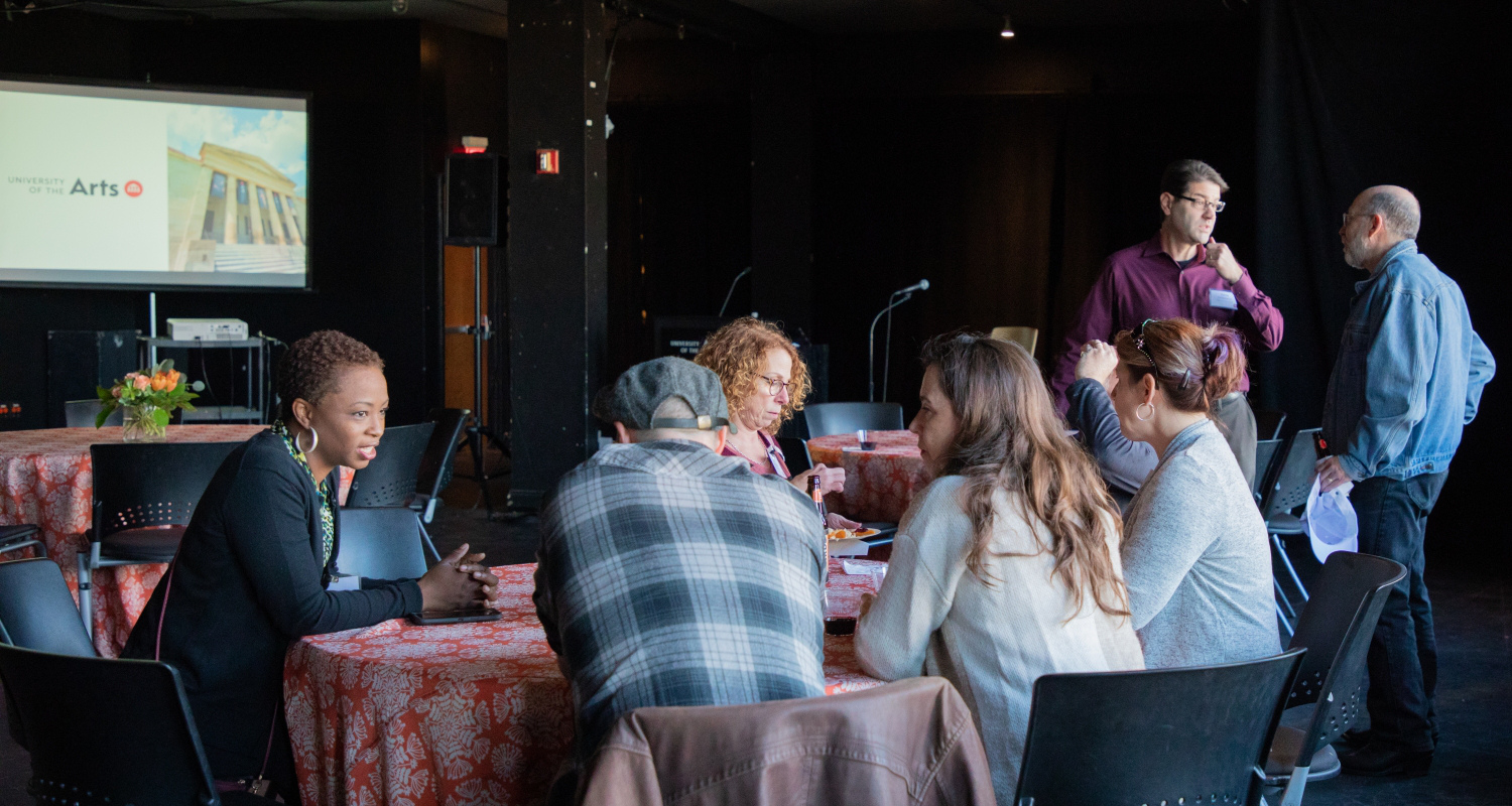 a group of parents sits around a round table with a tablecloth, discussing matters at the Parent Council reception 2019