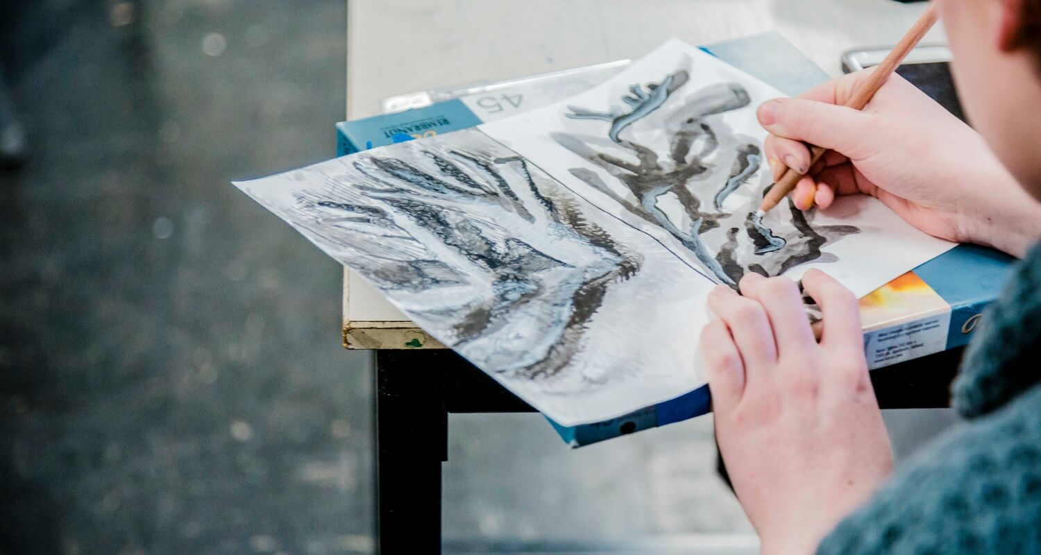 A student paints on paper
