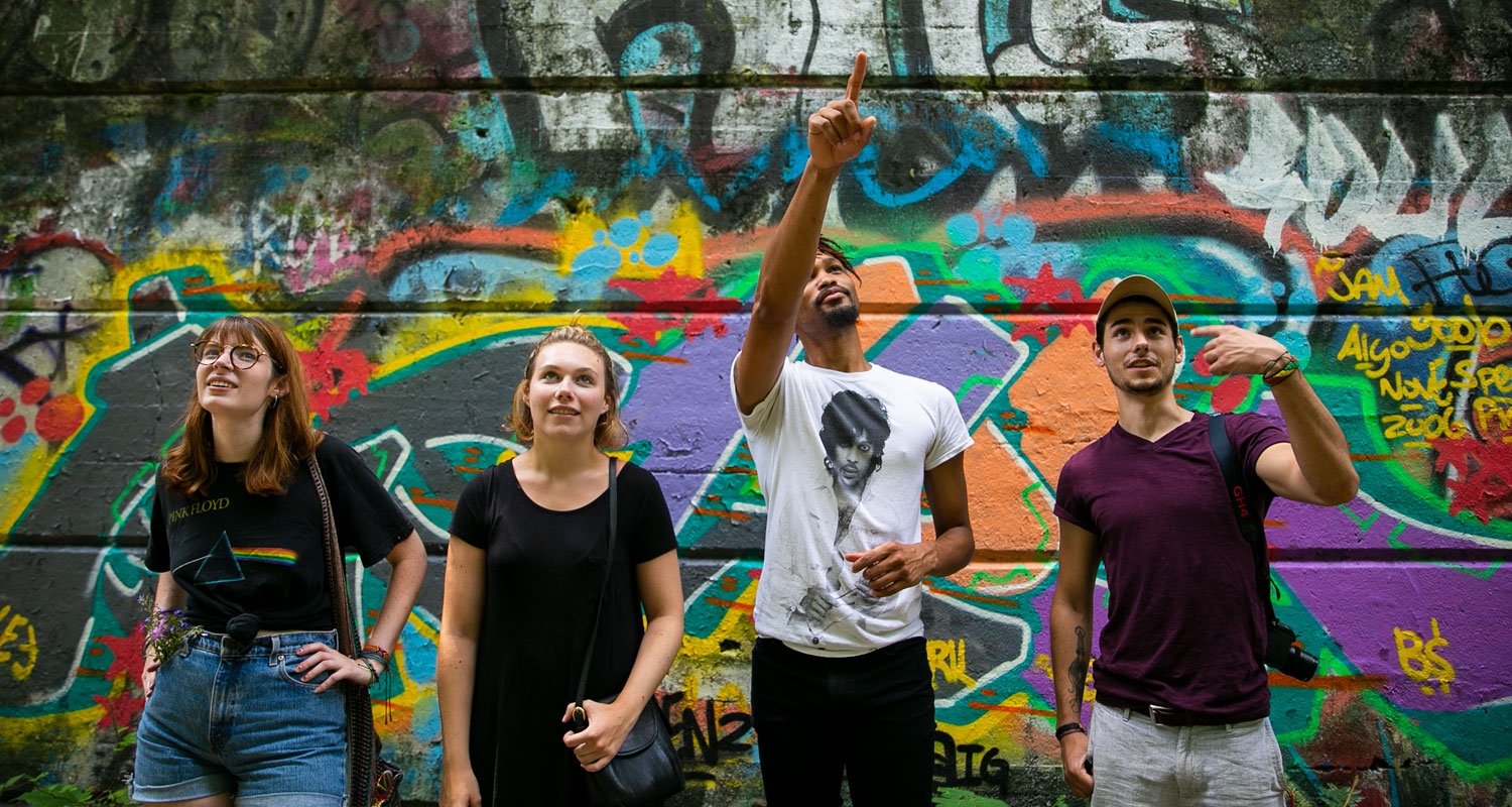 UArts students stand in front of a graffiti background experiencing life in Philadelphia