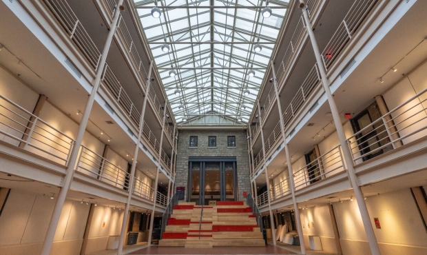 photo of empty Solmssen Court is a dramatic, glass-roofed, four-story atrium with catwalk balconies encircling a large open space. 