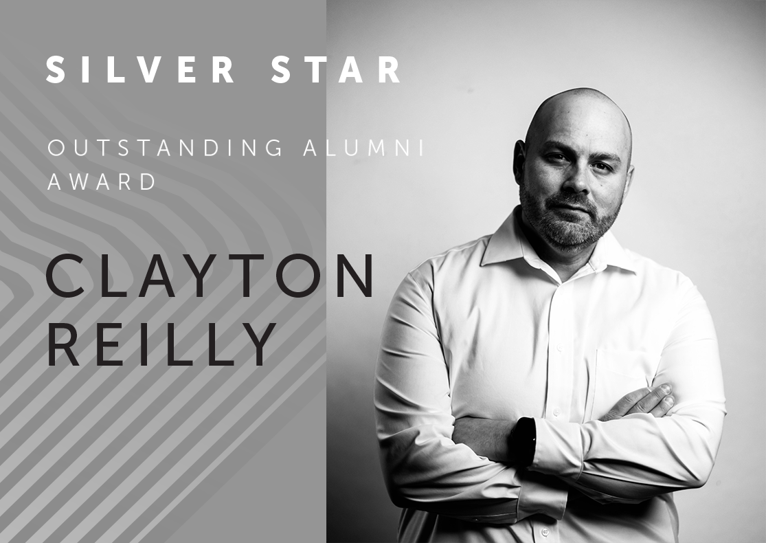 silver star award recipient clayton reilly depicted in black and white at the right. Clayton is wearing a simple white collared shirt with his hands folded over his chest, looking directly at the viewer with a serious but warm, unshaven face. identifying information is written on the left over a razzle dazzle gradient. 