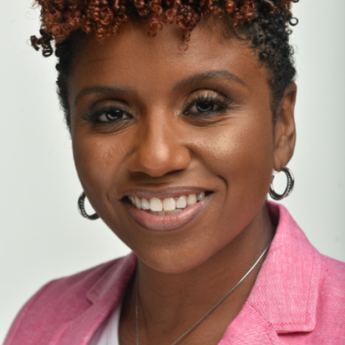 headshot of Lynette Luckers wearing a pink blazer and smiling at the camera