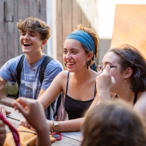 Students hang out outside around a table